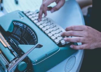 Hands, typing on vintage typewriter